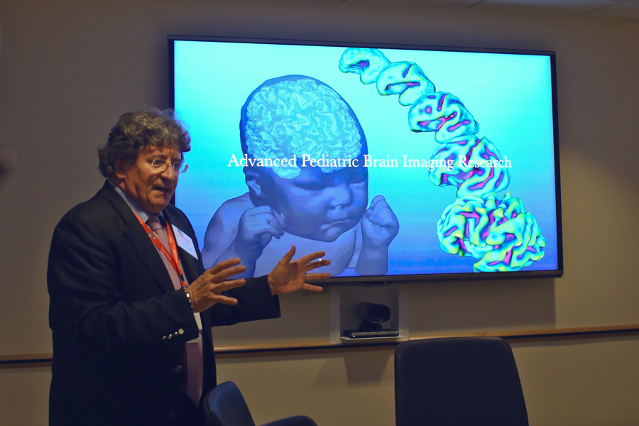 Man at a screen with a fetus and brain with words "Advanced Pediatric Brain Imaging Research"