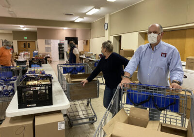 Man moving food in a cart at a food pantry